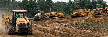 Image showcasing three tractors with Pull Scrapers